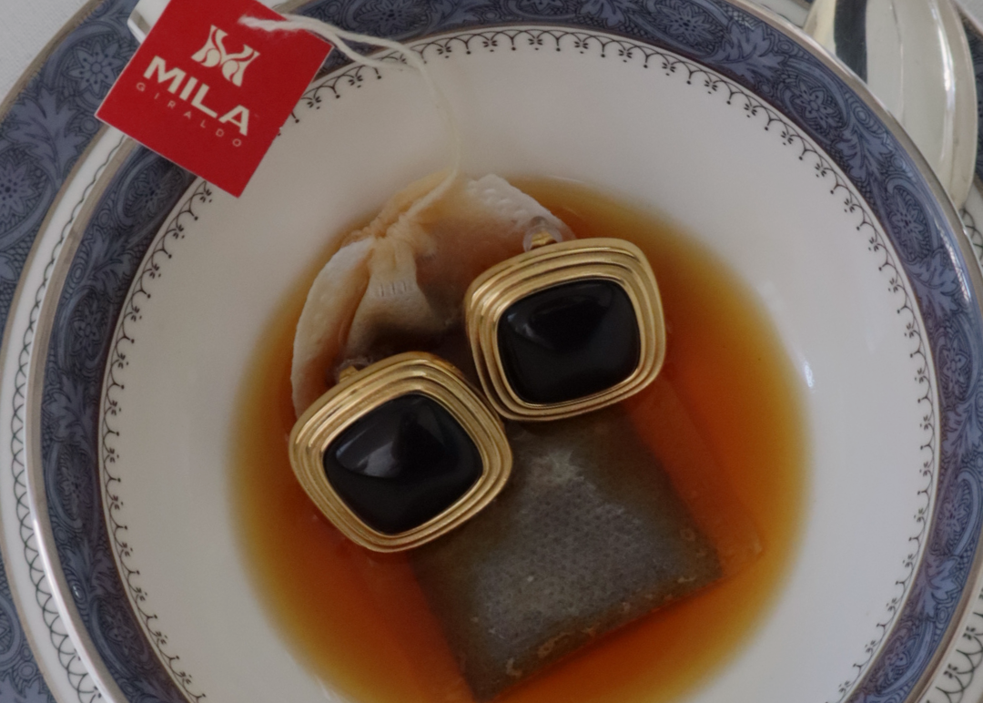 gold stud earrings with black square stone on tea bag
