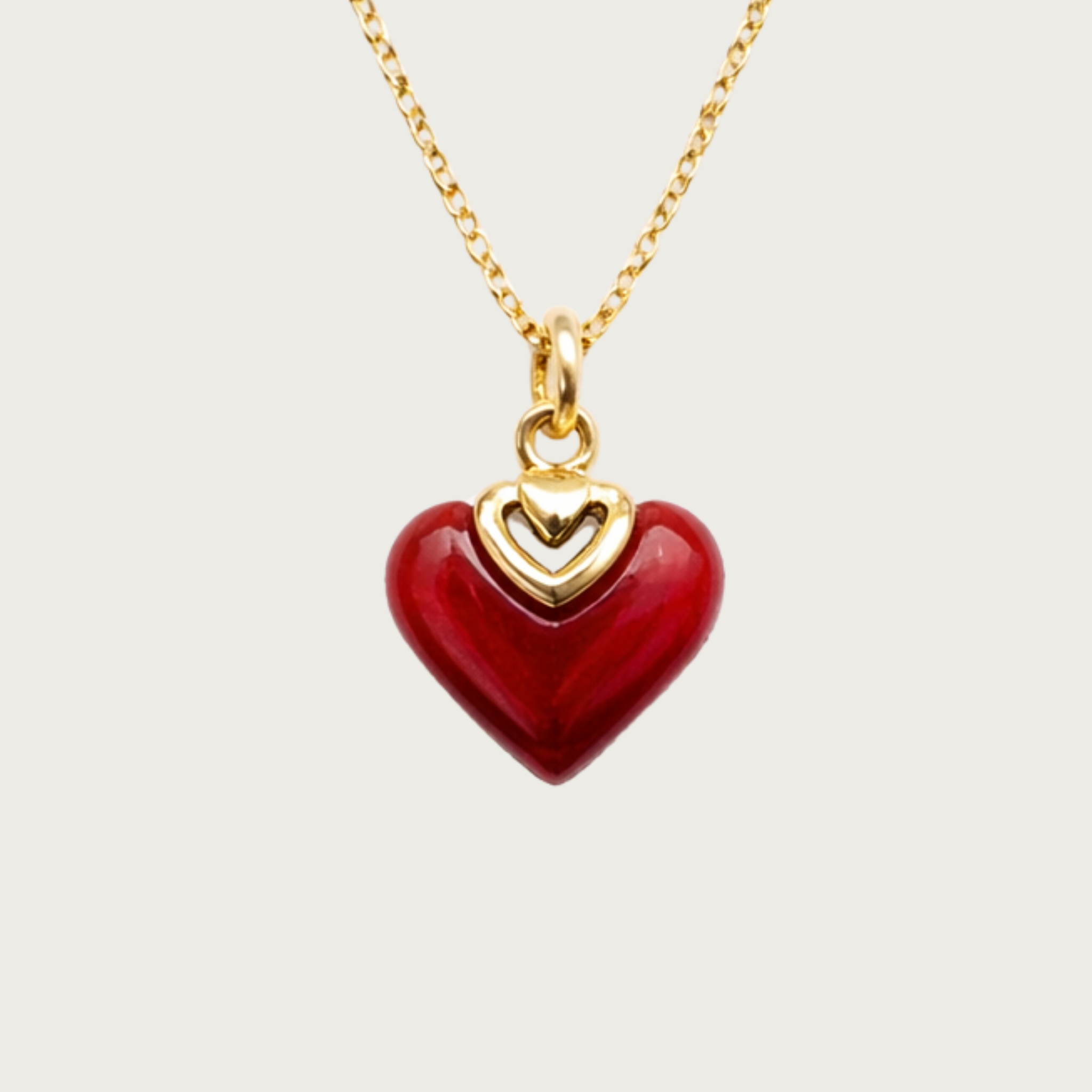 Gold necklace with a red heart pendant