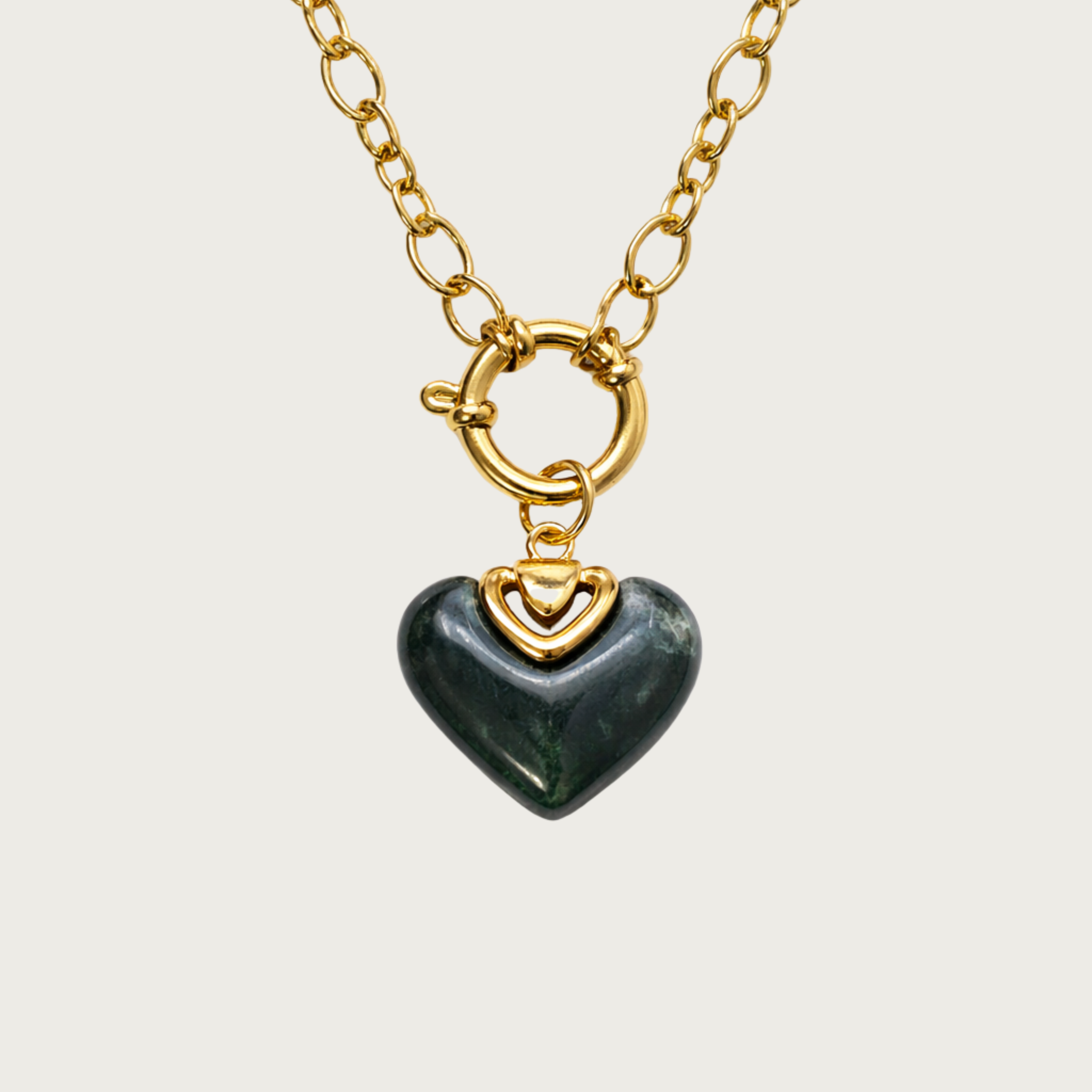 Gold necklace with a heart-shaped green stone pendant