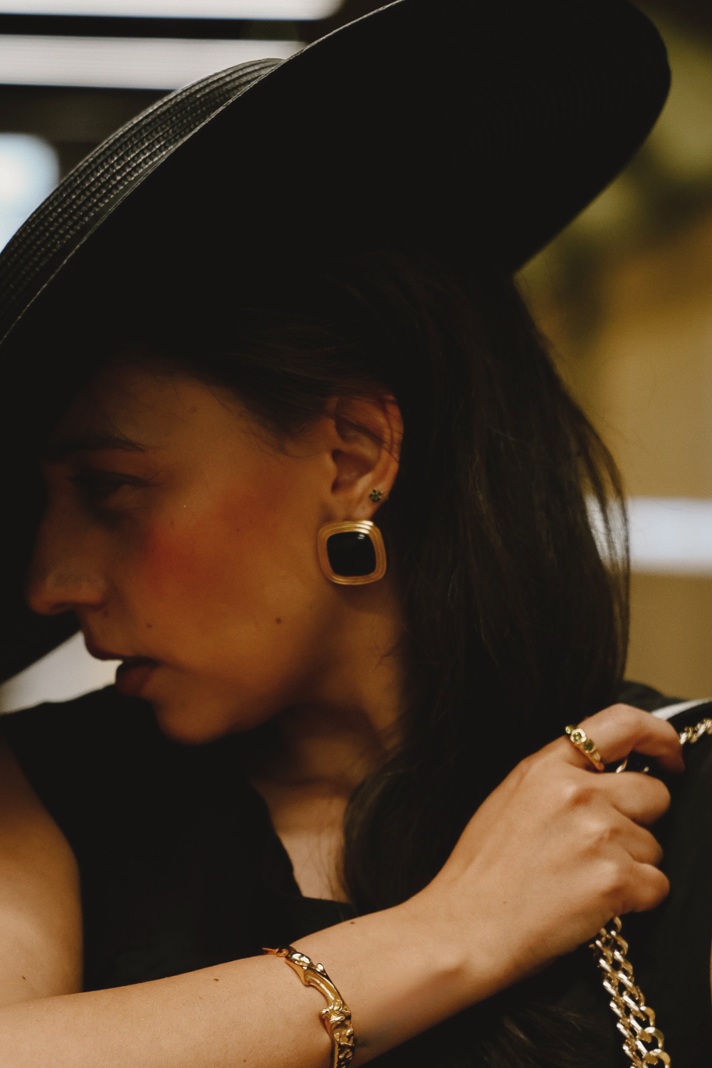 Model wearing Gemstone Statement Studs in 18k Gold PVD with a deep black gemstone centre, styled alongside the Maria Crunchy Bangle for a bold sculptural jewellery look by Mila Giraldo.