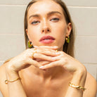 Model wearing vivid green Mia Resin Hoops by Mila Giraldo, styling bangles and rings for a cohesive, fashion-forward jewellery look.